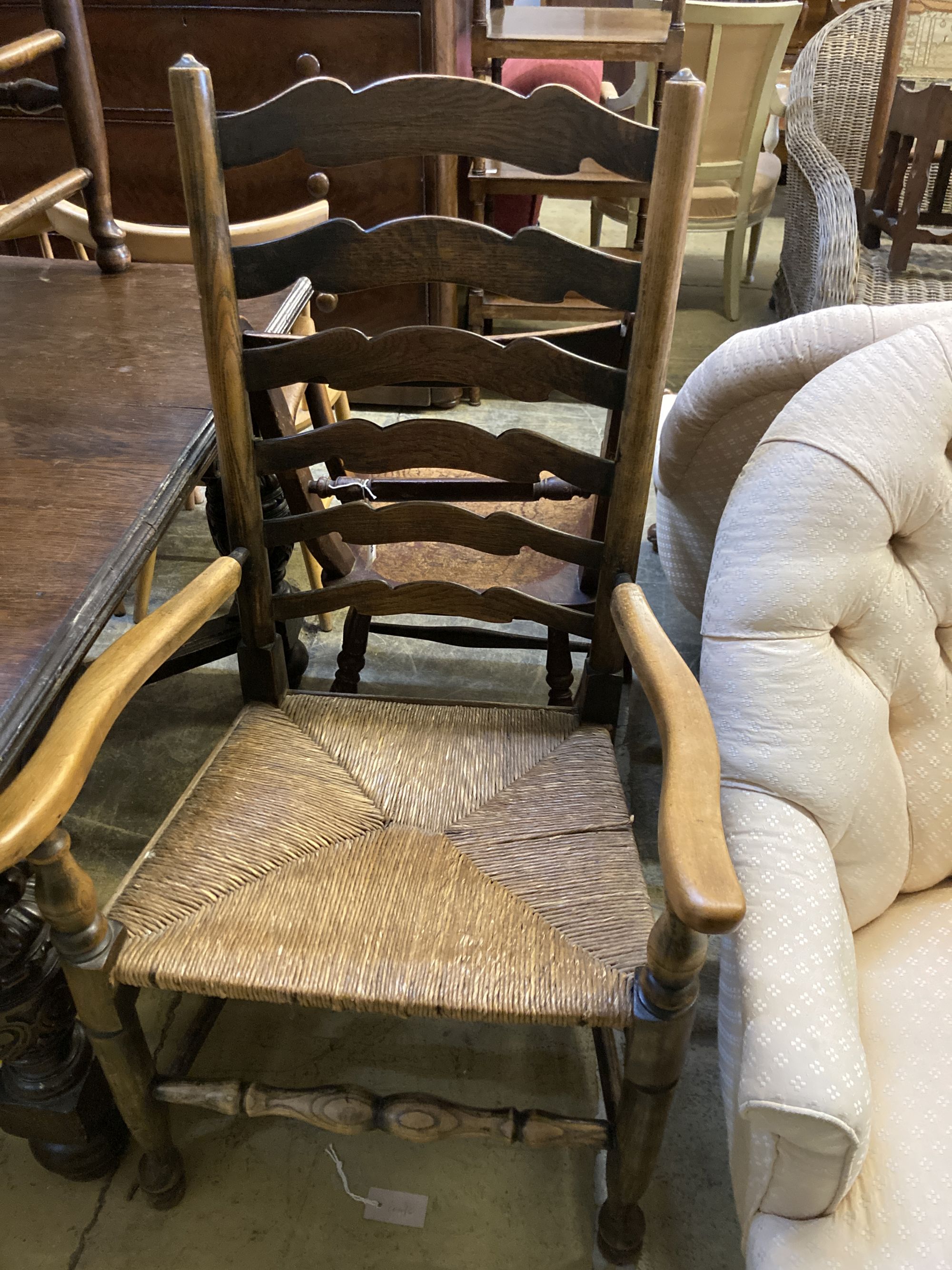A 19th century ash and beech ladderback elbow chair and a spindle back elbow chair (2)